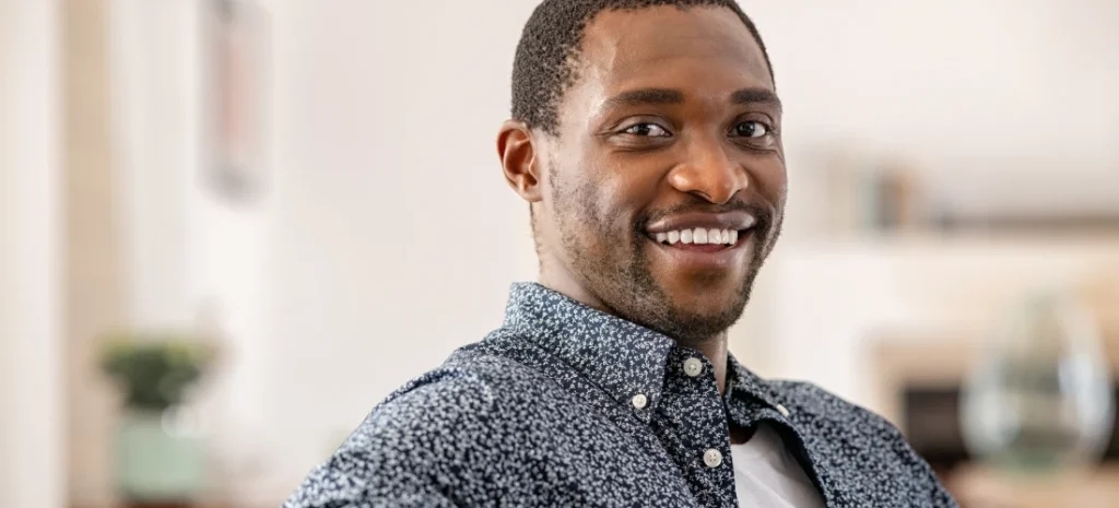 A man smiling in a blue shirt.