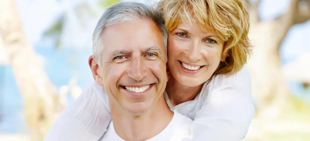 A smiling older couple embracing each other.